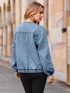 Détail de la veste en jean bleu clair avec épaules tombantes et ourlet élastique