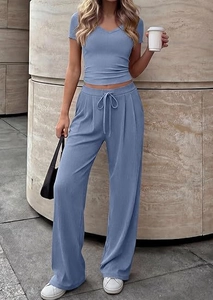 Close-up of blue ribbed knit fabric texture on V-neck top and drawstring wide-leg pants