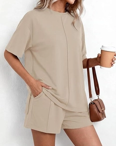 Dettaglio del set estivo albicocca con cuciture verticali e pantaloncini con tasche