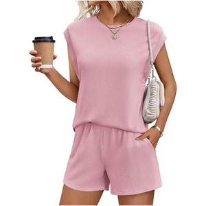 Close-up of pink knitted two-piece set showing ribbed texture and side pockets on shorts