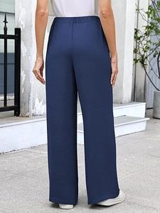 Detail showing high-waisted elastic waistband and navy textured fabric on wide leg pants