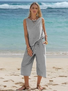 Detail of summer two-piece striped sleeveless top and wide-leg trousers on a beach