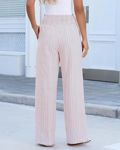 Detail of high waisted smocked waist and vertical stripes on pink wide leg pants