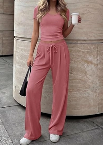 Detail of pink V-neck top and high waist wide leg trousers with ribbed knit texture