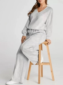 Detail of light gray knit set showing V-neck texture and drawstring waistband on trousers