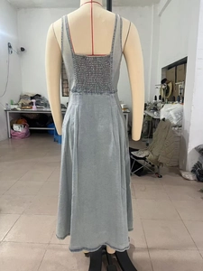 Détail du design smocké élastique au dos sur cette robe d'été en denim bleu clair