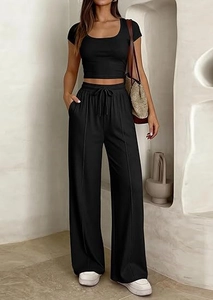 Dettaglio dei pantaloni neri a vita alta con coulisse elastica e cucitura decorativa