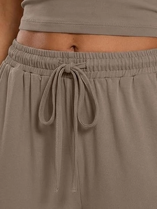 Detail view of elastic waist with adjustable drawstring on casual knit trousers