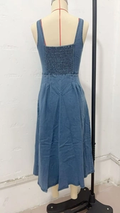 Détail du dos smocké élastique sur la robe mi-longue en jean bleu de style vintage