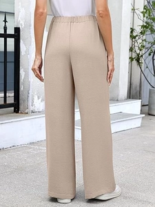 Detail of high waist wide leg pants showing beige pleated fabric texture from the back view