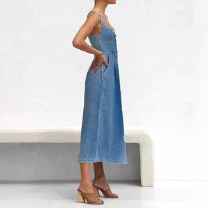 Détail d'une robe mi-longue en jean bleu clair délavé avec boutons et poches latérales