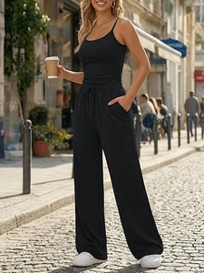 Detail of high-waist wide-leg pants with adjustable drawstring and side pockets in black