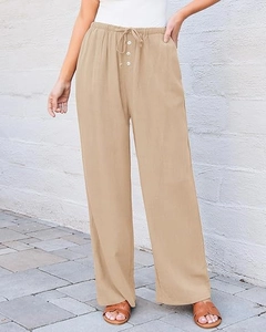 Detail of high waisted wide leg trousers with elastic waistband drawstring and white buttons
