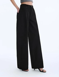 Detail of high-waisted black wide-leg trousers with minimalist side pocket design