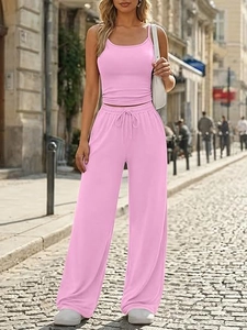Pink two-piece set featuring camisole and wide-leg trousers on a scenic street