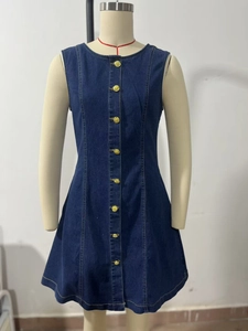 Close-up of golden buttons and yellow contrast stitching on dark blue denim dress