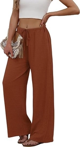 Detail of rust red wide leg trousers showing drawstring waist and crepe fabric texture