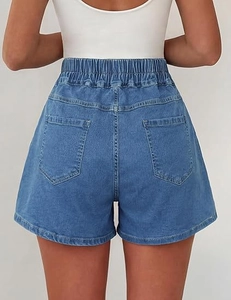 Dettaglio della vita elastica alta e delle tasche posteriori sui pantaloncini di jeans