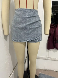 Detail of high waisted asymmetric wrap denim skirt in light grey with snowflake wash texture