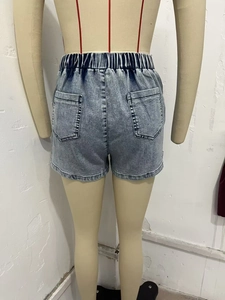 Rear view of light blue washed denim shorts featuring elastic waist and dual back pockets