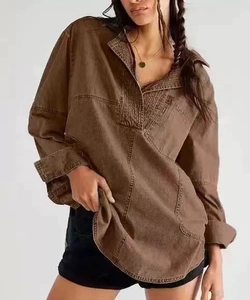 Vista dettagliata della camicia oversize in cotone marrone con scollo a V e cuciture