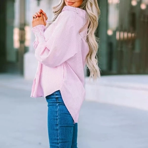 Detail of pink striped blouse featuring elastic pleated cuffs and irregular split hemline