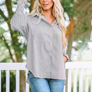 Detail of loose oversized striped shirt with button-down front and chest pocket