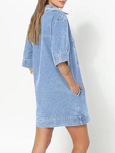 Detail showing white scalloped embroidery on a light blue denim dress neckline and back