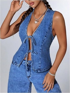 Détail du gilet en jean bleu délavé avec deux nœuds papillons et une coupe ajustée