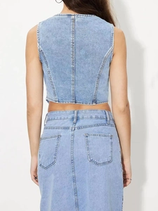 Détail du dos d'un ensemble en jean bleu clair avec coutures de poches et coupe courte