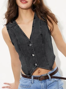 Détail d'un gilet en jean gris foncé avec col en V profond et boutons métalliques