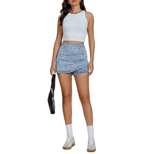Detail of high waisted light blue denim skort with asymmetrical wrap and cross design