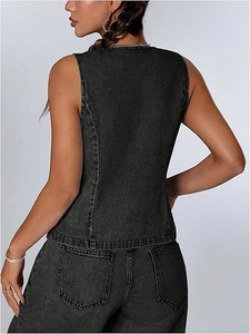 Gros plan détaillé sur la texture délavée et les coutures du gilet en jean gris foncé