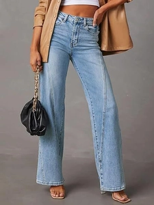 Detailed view of high-waisted wide-leg jeans with unique vertical seam and denim texture