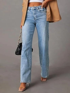 Detail showing high-waisted light blue denim jeans with unique diagonal patchwork stitching