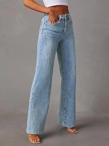 Close-up of high-waisted light blue denim jeans with diagonal stitching and wide-leg fit