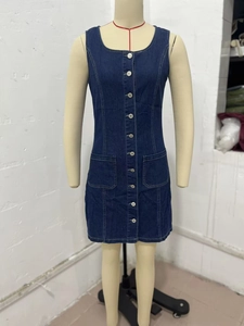 Detailed view of dark blue denim sleeveless dress with front buttons and square pockets