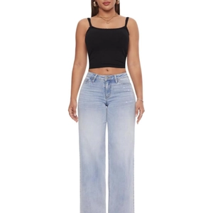 Détail du jean large bleu clair à taille haute avec une finition délavée vintage