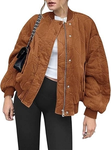 Detail of caramel quilted bomber jacket showing wave texture and metallic zip closure