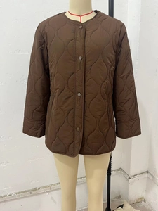 Detail of brown quilted jacket with wave patterns and metal snap buttons