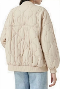 Detail of loose-fit beige onion-quilted jacket with ribbed collar and drop shoulder design