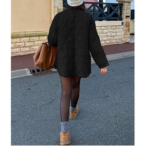 Back view of a black quilted jacket with classic gourd stitching in a street setting