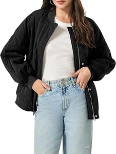 Detail of oversized black quilted bomber jacket with silver zipper and snap buttons