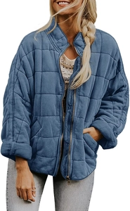Détail d'une veste matelassée bleue avec fermeture éclair dorée et col montant chic