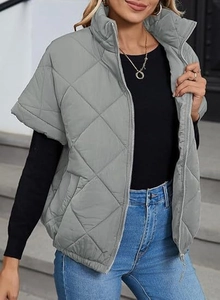 Detail of grey diamond-quilted vest with stand collar and zipper for autumn layering