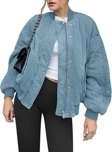Detail of blue-grey quilted bomber jacket featuring wavy stitching and ribbed trims