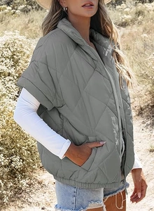 Detail of grey quilted vest with diamond pattern and zipper on outdoor background