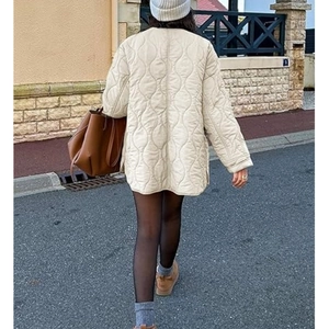 Rear view of beige quilted jacket with wavy stitching and loose casual fit