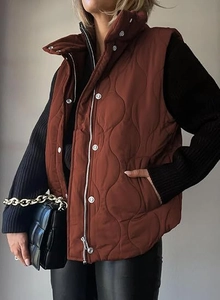 Detail of caramel brown wave-quilted vest featuring a zipper and silver snap buttons