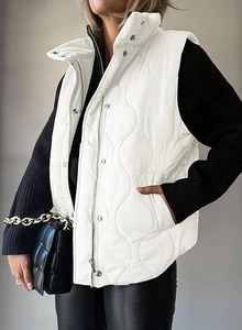 Detail of white quilted vest with wave stitching and metal snap button closure